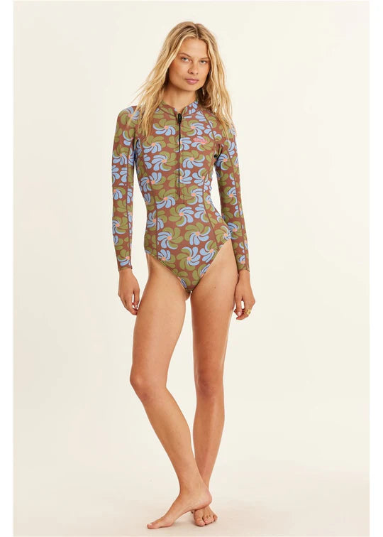 Woman wearing a patterned long-sleeve swimsuit on a plain background shed nine