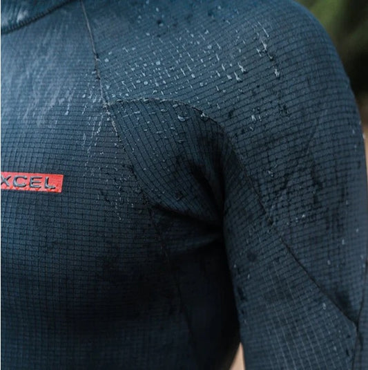 Close-up of a person wearing a dark blue textured jacket with EXCEL logo on sleeve.