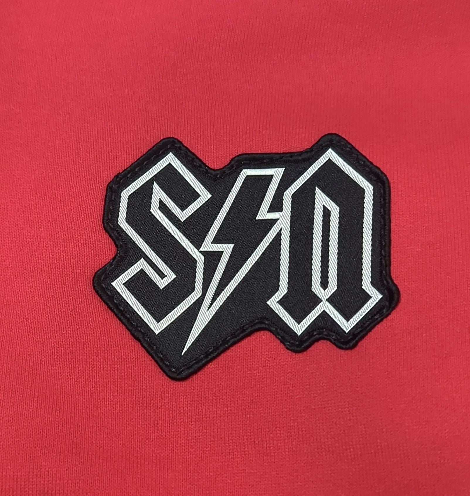 Black and white logo patch on a red background