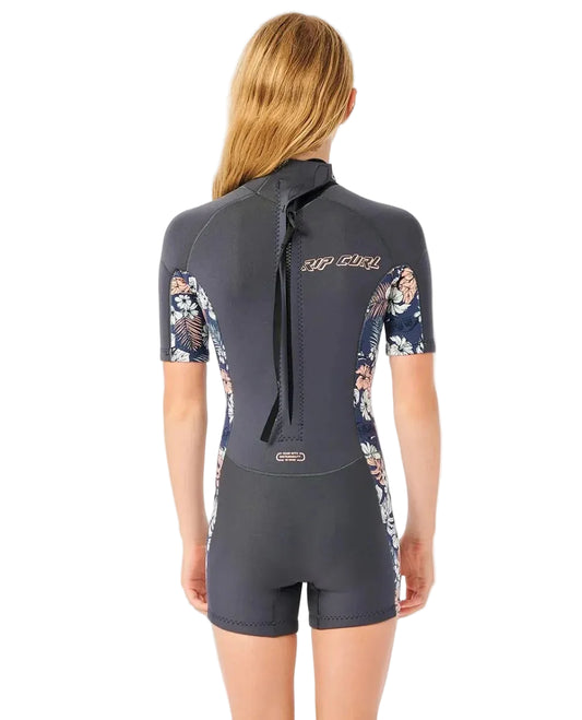 Woman wearing a gray and floral short-sleeve wetsuit on a white background shed nine
