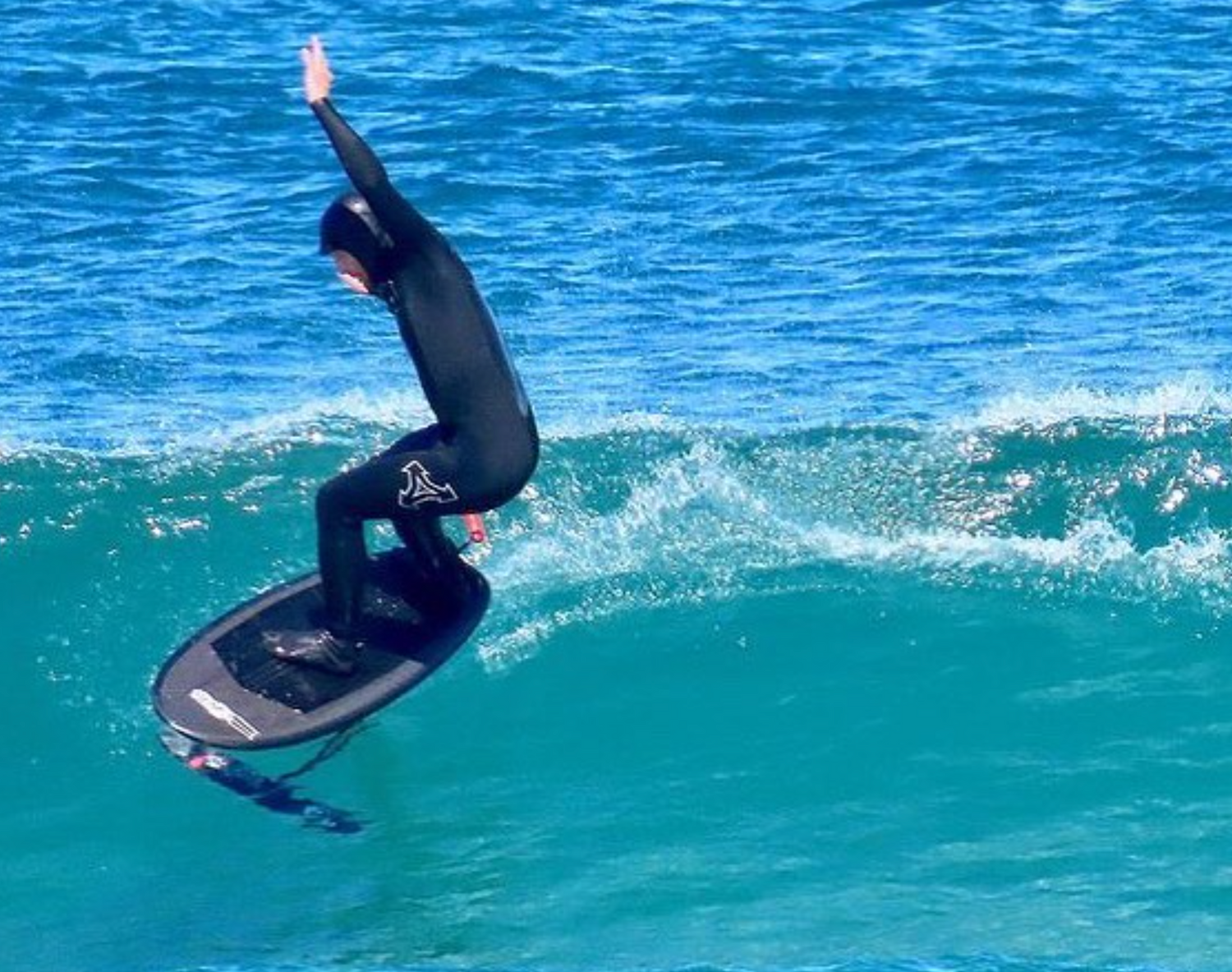 Person in a wetsuit on a surfboard in the ocean