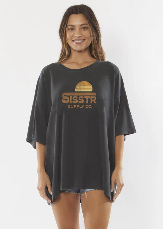 Woman wearing a black oversized t-shirt with 'SISSTR Supply Co' logo on a white background SHED NINE