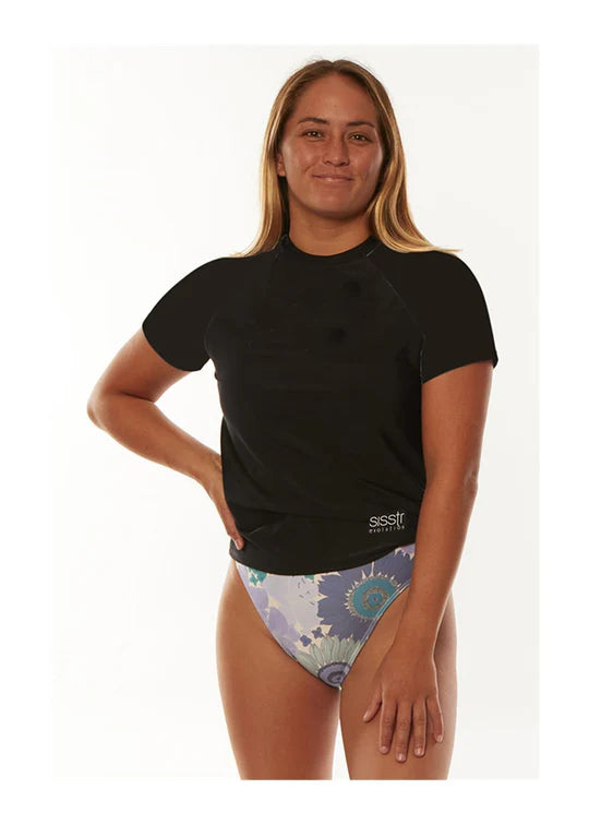 Woman wearing a black rash guard and patterned swim bottoms on a white background shed nine