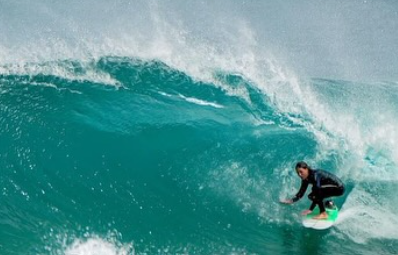 Person surfing on a wave in the ocean