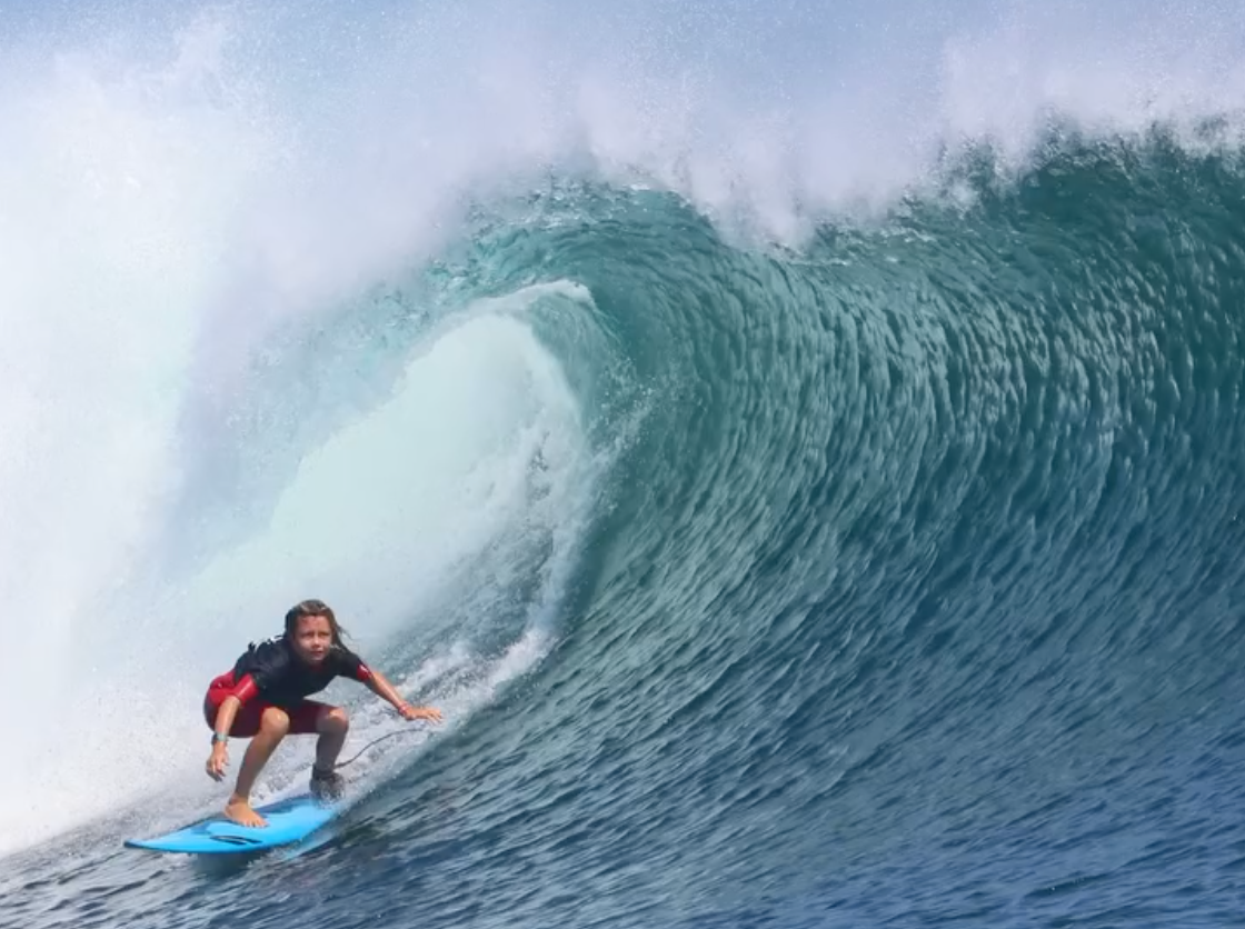 Person surfing on a large wave in the ocean