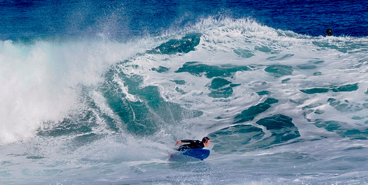 Person surfing on a large wave in the ocean