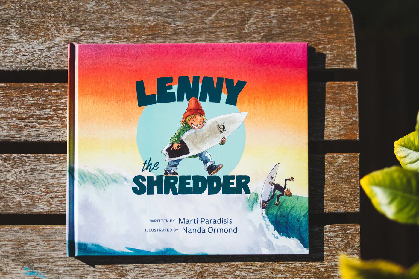 Children's book titled 'Lenny the Shredder' on a wooden surface with a colorful cover. shed nine