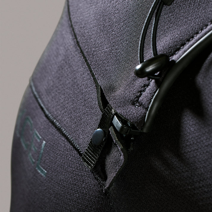 Close-up of a gray wetsuit with a zipper and brand logo on a neutral background shed nine