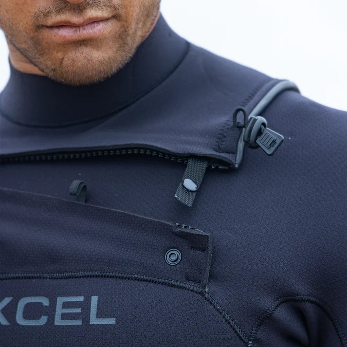 Close-up of a person wearing a black wetsuit with 'Excel' branding. shed nine