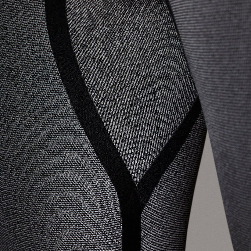 Close-up of a textured gray fabric with a V-shaped cutout. shed nine