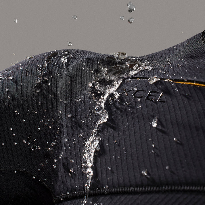 Water droplets on a black wetsuit with a brand logo. shed nine