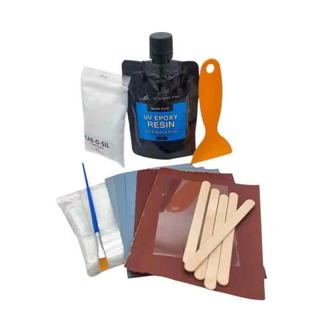 SurfBoardStudio UV Epoxy Repair Kit, resin pouch and repair materials laid out