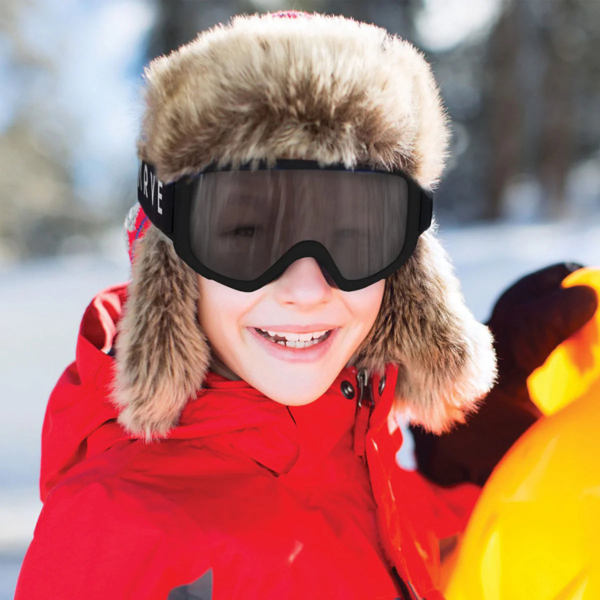 Child wearing a red coat, fur-trimmed hat, and goggles in a snowy setting shed nine