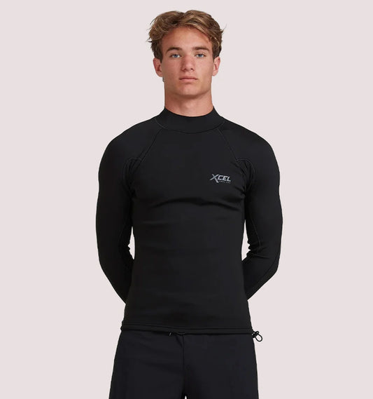 Person wearing a black XCEL wetsuit on a light pink background