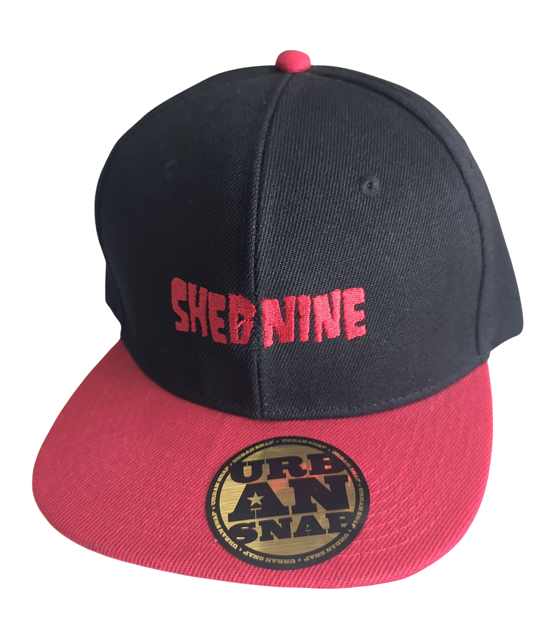 Black and red cap with 'Shed Nine' text on a white background