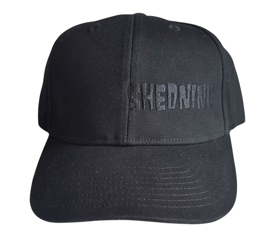 Black cap with 'SHEDNINE' text on a white background