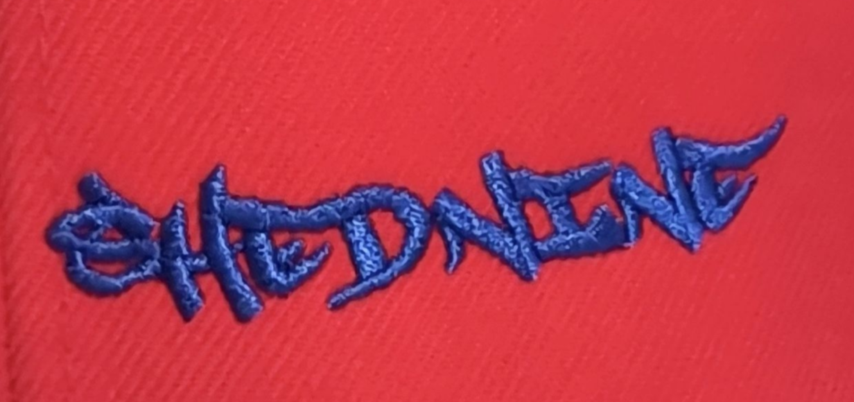 Red and blue snapback cap with embroidered logo on a white background
