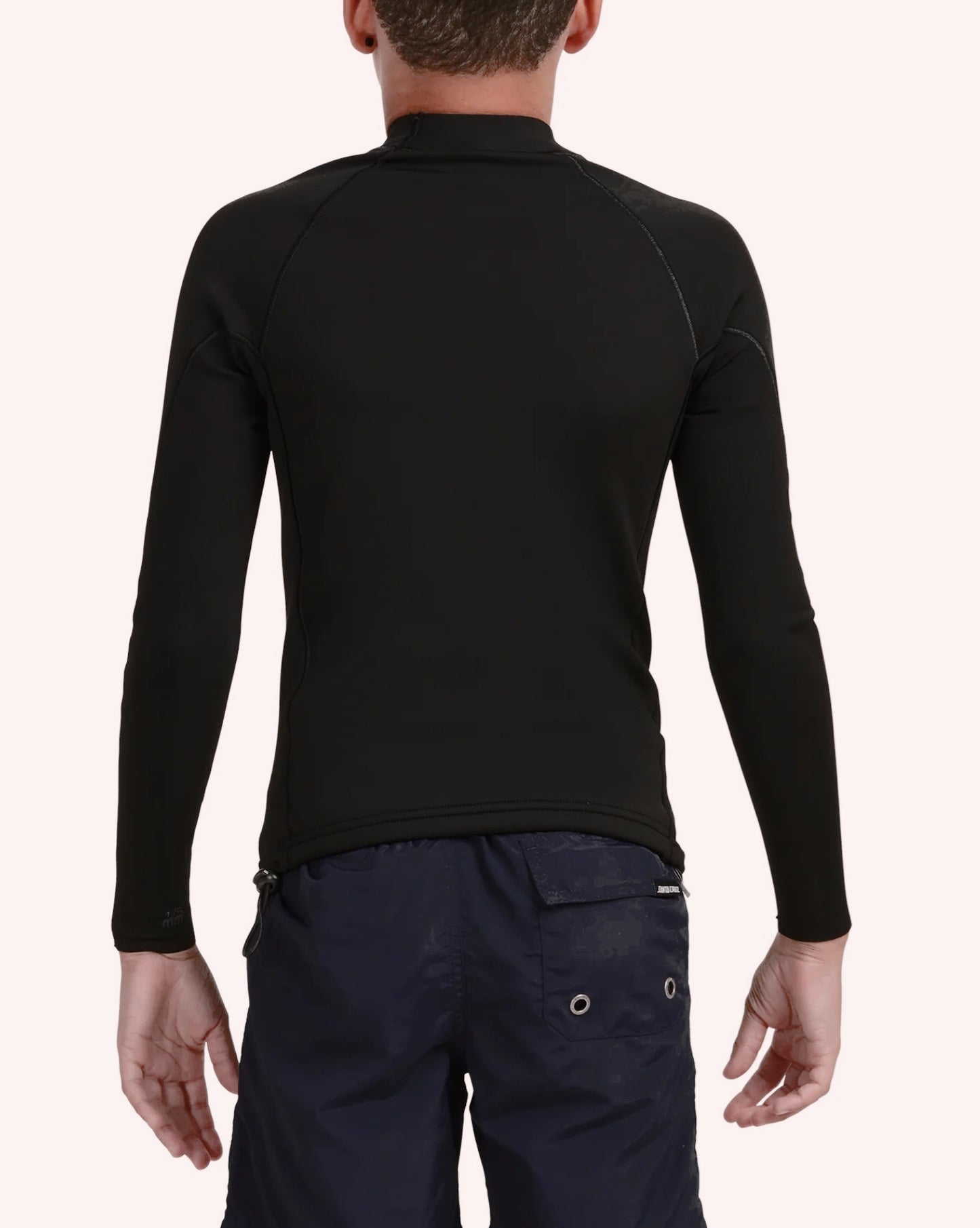 Person wearing a black long-sleeve shirt and navy pants on a white background