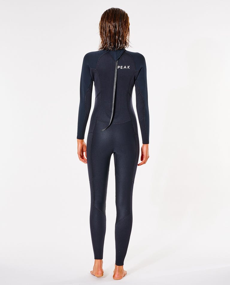 Person wearing a black wetsuit with 'Peak' branding on a white shed nine background