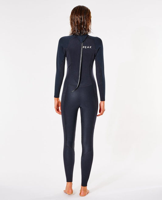 Person wearing a black wetsuit with 'Peak' branding on a white shed nine background