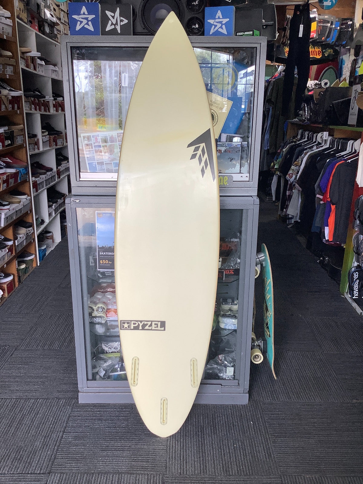 Bottom of second-hand Pyzel x Firewire surfboard with three empty fin boxes