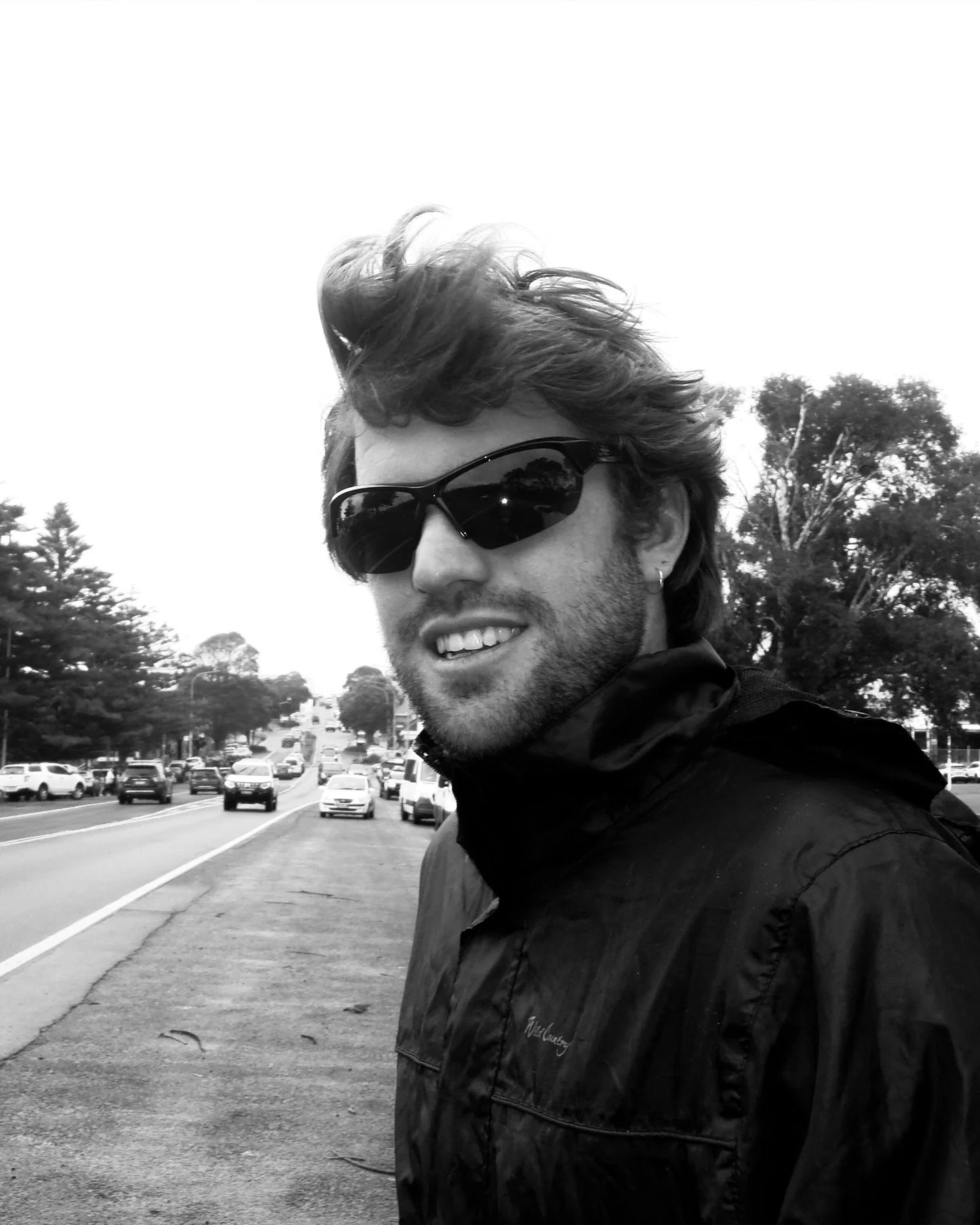 Black and white portrait of model wearing Ritual Vision Break & Enter Sunglasses in Polished Black / Reflective Blue shed nine