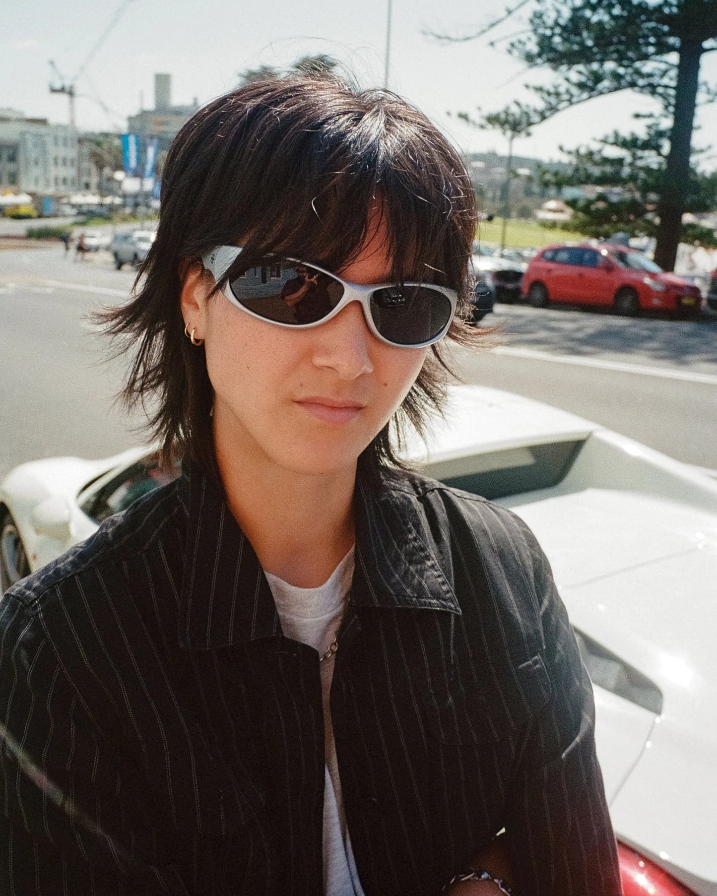 Outdoor portrait of model wearing Ritual Vision Demon Speed Sunglasses in Matte Chrome / Blue Reflective Polarised 65 mm shed nine