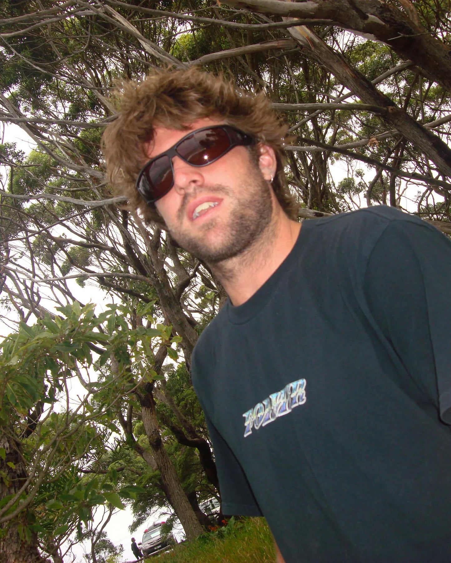 Outdoor lifestyle image of model wearing Ritual Vision The Vacationer Sunglasses in Matte Black / Black Polarised shed nine