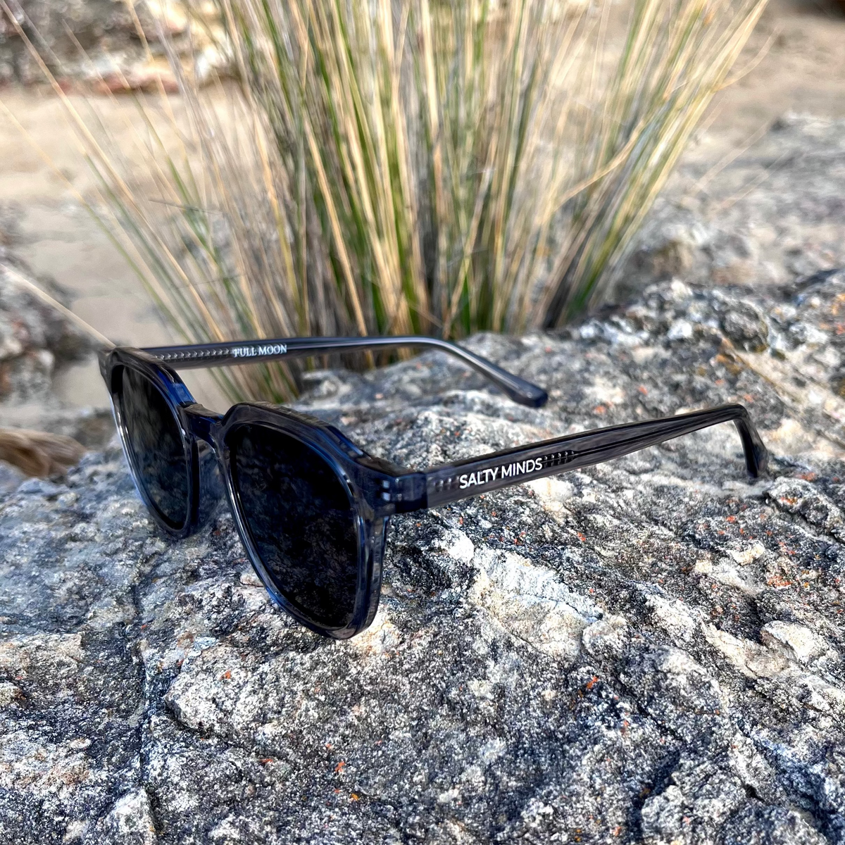 Salty Minds Full Moon sunglasses on coastal rocks