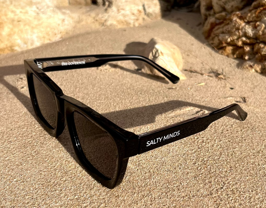 Salty Minds The Governor black sunglasses on the beach