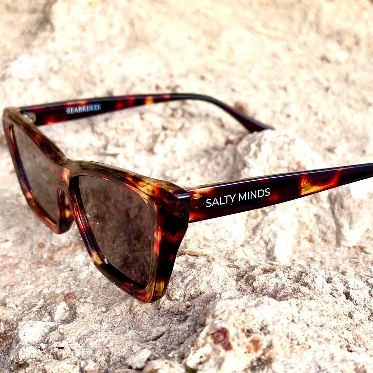 Salty Minds Seabreeze tortoise sunglasses on coastal rocks