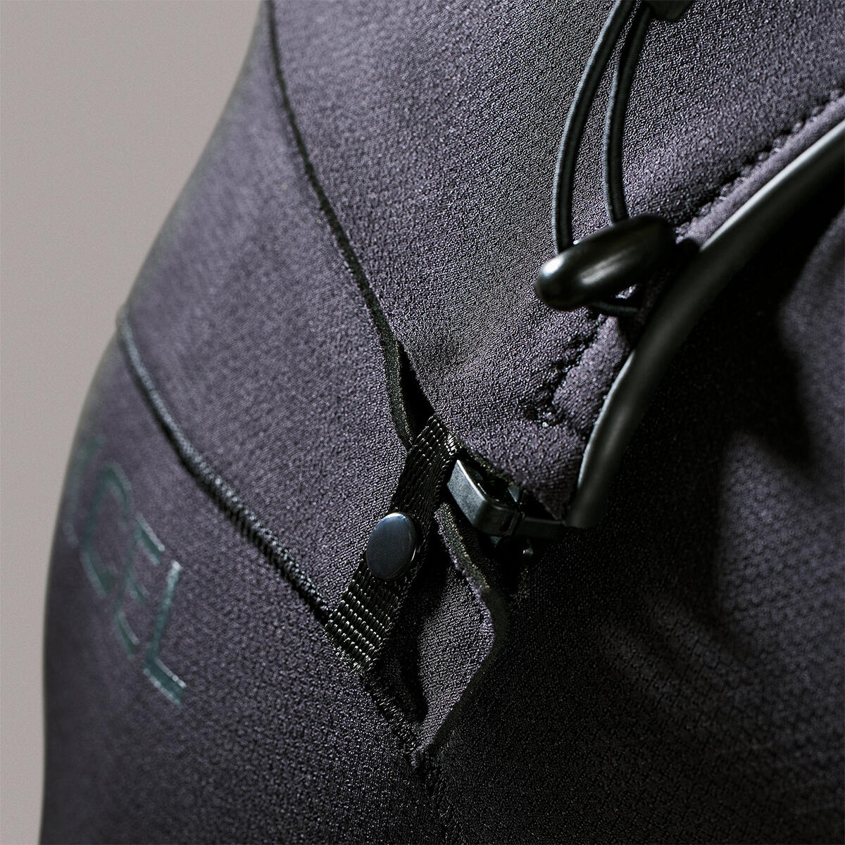 Close-up of a gray wetsuit with a zipper and brand logo on a neutral background shed nine 