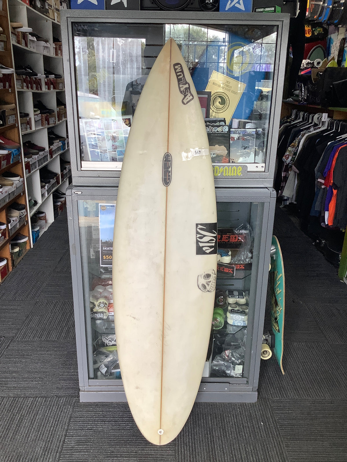 White PISC Asylum used surfboard deck with yellowing, surface marks and skull graphic