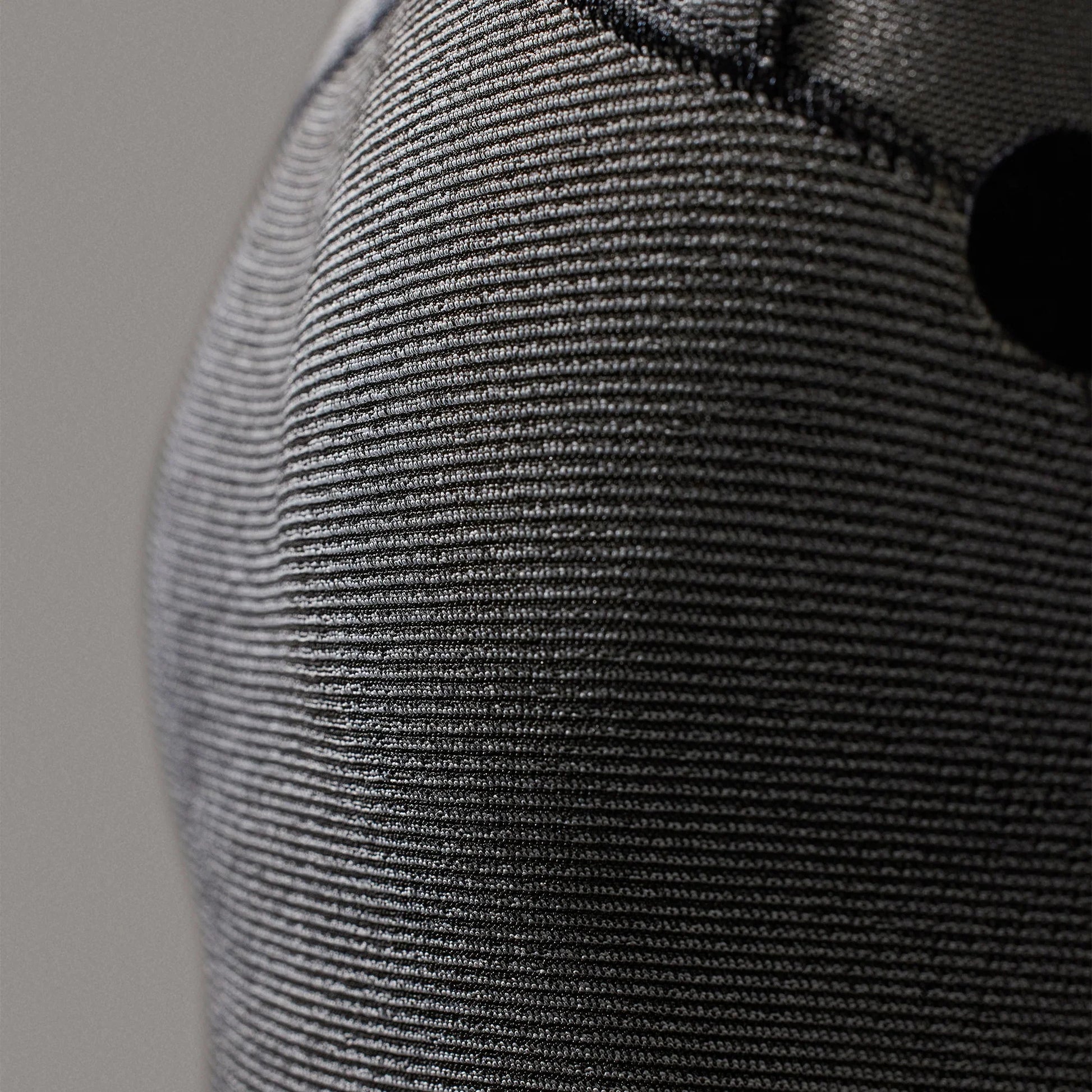 Close-up of a textured gray fabric with a subtle pattern on a neutral  shed nine background