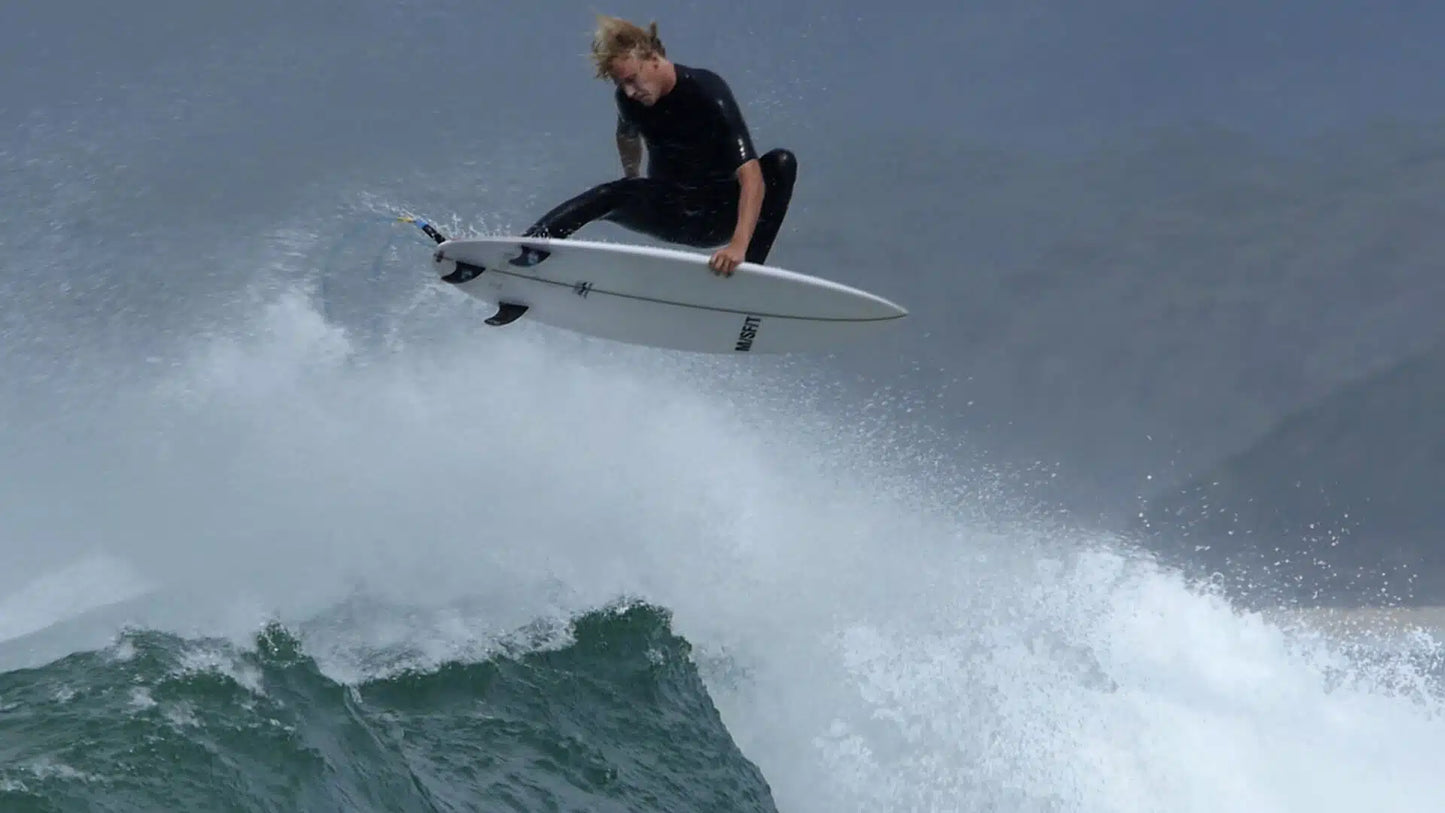 Surfer riding a wave wearing Zion Wesley 2/2mm GBS Long Arm Springsuit Wetsuit in black shed nine